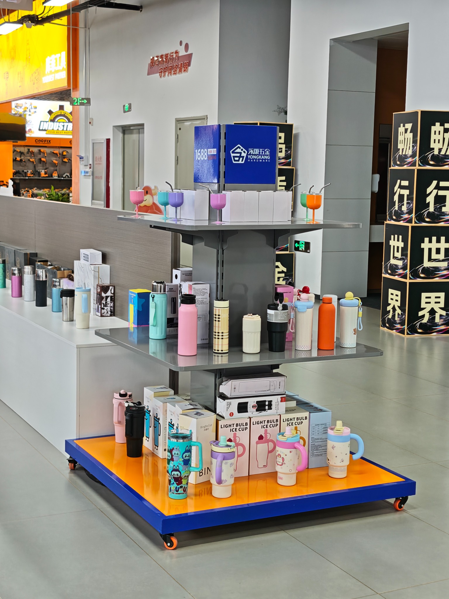 Real selection-center display tables holding colorful bottles, tumblers, and stemmed cups